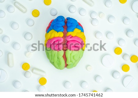 The brain is surrounded by pills. Useful neurological medications. Treatment of brain diseases. Nootropic drugs. Memory improvement. The 3D model of the brain is on a white background. Neurology. Royalty-Free Stock Photo #1745741462