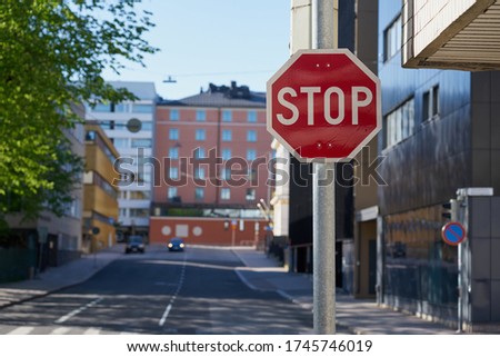                            Stop symbol with blurred street of the city on a background.