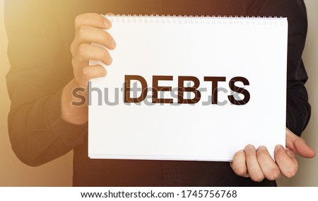 Man holding brochure with DEBTS text on grey background. Mock up for design