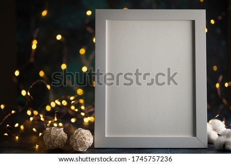 White frame for design, layout, Mockup. Against the background of night lights, with designer accessories. Lettering on the frame, logos and font advertisements.