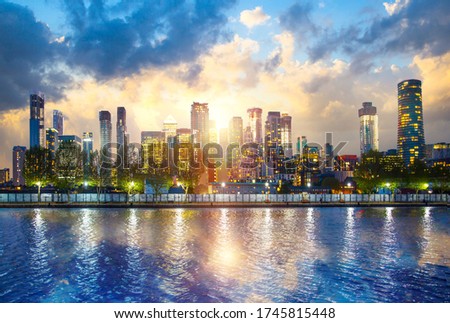 Beautiful sunset at Canary Wharf, financial and residential modern district of London. Skyscrapers and light reflection in dock's water. UK
