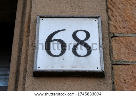 Number 68 on Wall Plaque beside Entrance Door 