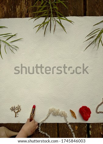 Prepairing background for flatlay photo, kids hand taking away a lipstick. Above top view close up