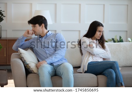 Mad offended man and woman sit separately back to back on couch at home having family fight or quarrel, unhappy young couple ignore avoid talking after disagreement, breakup, divorce concept Royalty-Free Stock Photo #1745850695