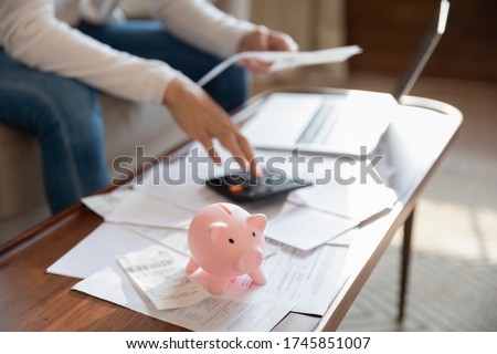Close up of woman manage household finances feel economical provident saving money in piggy bank for future, female pay bills online, calculate home expenditures expenses, investment concept Royalty-Free Stock Photo #1745851007