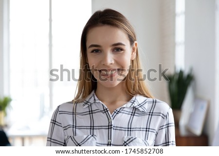 Head shot close up portrait of happy young female company employee worker. Smiling millennial businesswoman trainer lecturer coach teacher financial advisor looking at camera, standing in office. Royalty-Free Stock Photo #1745852708