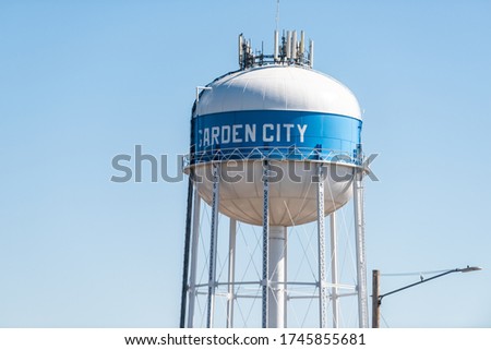 View of water tower sign for Garden City in Kansas countryside industrial town closeup isolated against sky