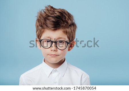 portrait of handsome little boy in glasses look at the camera, isolated on blue background Royalty-Free Stock Photo #1745870054