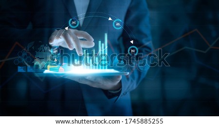 Businessman using tablet analyzing sales data and economic growth graph chart on virtual interface. Business strategy. Abstract icon. Digital marketing. 