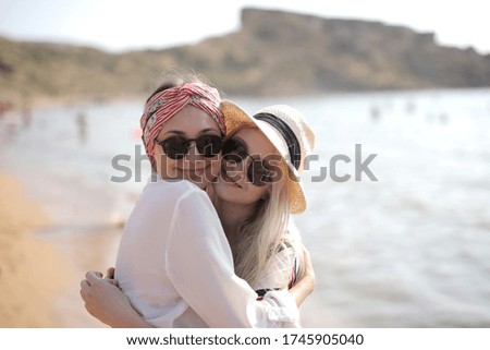 A selective focus shot of two girls with glasses at the beach