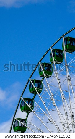 Green cars of ferris wheel 