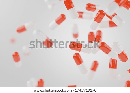Red capsules pill falling on white background copy space