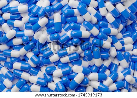 White and blue pills capsules on top full picture