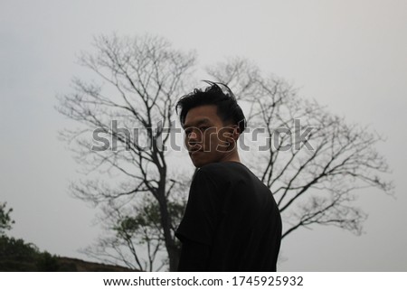 picture of a man with a tree in background.