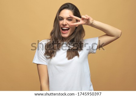 Portrait of young beautiful cheerful girl smiling looking at camera over beige background.