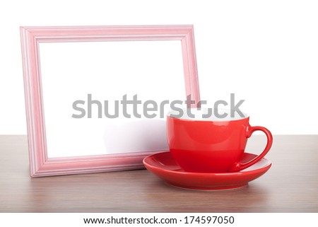 Photo frame and coffee cup on wooden table. Isolated on white background