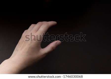 Female hand on brown background. Close up. Hand showing size gesture