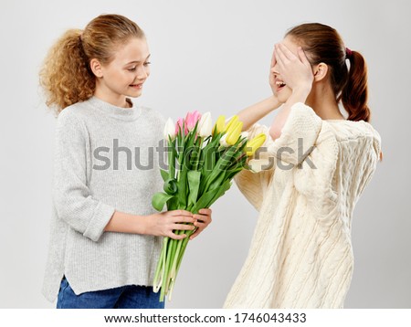 Beautiful girl with a bouquet of flowers and a young mother