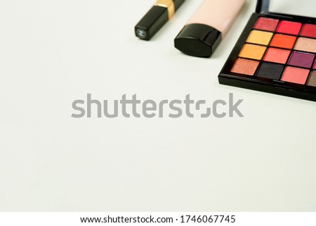 a palette of bright shadows, Foundation and mascara isolated on a light grey background with space for your text