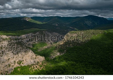 Mountains covered by a young green forest in cloudy weather in spring. Before the storm. Crimean mountains, Chernorechensky canyon