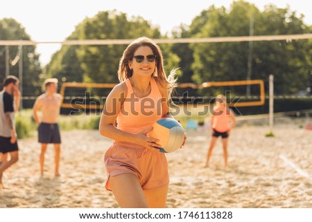 young woman plays beach volleyball with friends Royalty-Free Stock Photo #1746113828