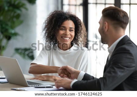 Smiling African American businesswoman advisor broker shaking client customer hand at meeting, making great deal after successful negotiations, executive mentor greeting new worker intern Royalty-Free Stock Photo #1746124625