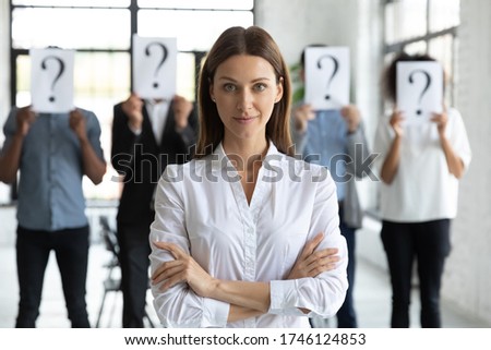 Head shot portrait confident businesswoman hr manager with candidates standing behind, workers hiding faces behind papers with question marks, identity and equality at work, recruitment process