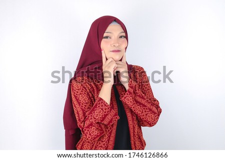Young Asian Islam woman wearing headscarf with smile in face to camera. Indonesian woman with hand touch on face skin. Beauty concept.