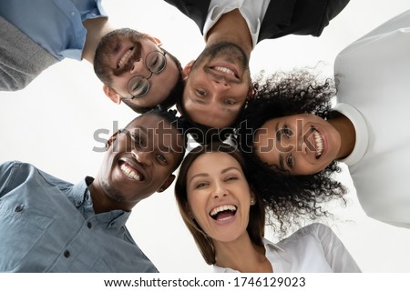Portrait close up bottom view happy faces of diverse employees team standing in circle, looking at camera, smiling businesswomen and businessmen engaged in team building, posing for photo Royalty-Free Stock Photo #1746129023