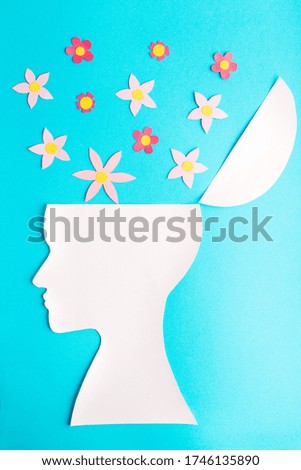 Blue background with many color flowers from head, paper, woman face, profile, psychology of love and happy