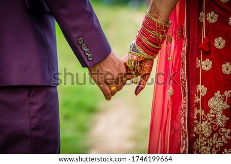 Young adult male groom and female bride holding hands together,Hands of newlywed couple.