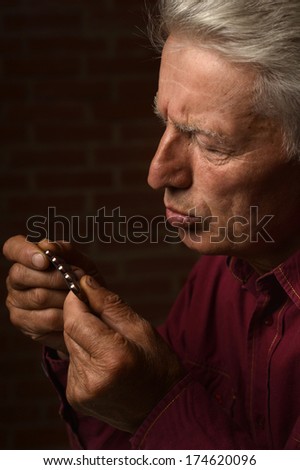 Mature man with pills in a shirt on a brick background