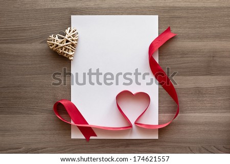 Photo blank sheet, ribbon with heart on textured wood background