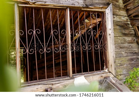 old wooden houses window with bars