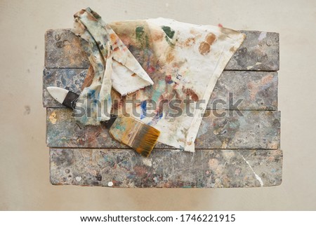 Top down view at cloth and paint brush over old wooden chair on white background, decorating and restoration concept, copy space