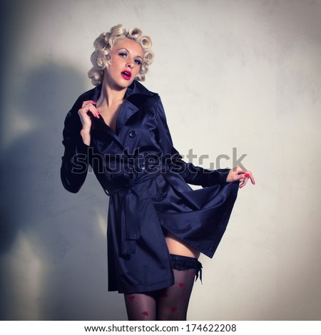 beautiful young woman  in old fashion clothes representing pinup and retro style. Girl dressed in a black cloak with red lipstick.