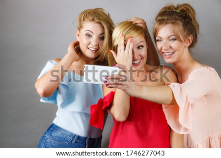 Fashionable women taking selfie self picture using smartphone having fun enjoying friends time.