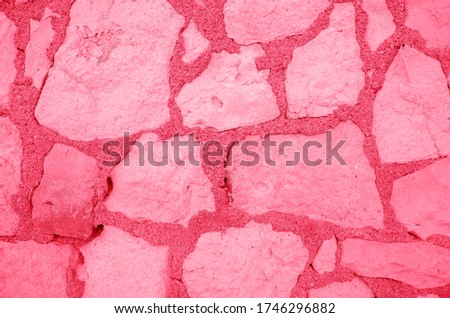 Pink background. Fragment of old house wall close-up.  Peeling plaster on concrete surface. Cracks in paint. Copy space. Place for text. Selective focus image.