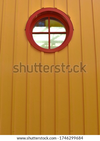 There is a small window on the yellow wall.
