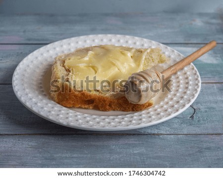 Quick lunch with a sandwich and a sandwich with butter and honey on a white plate and a spoon for honey