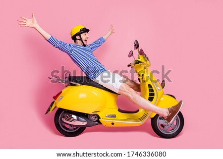 Profile side view of his he nice attractive handsome cheerful cheery crazy foolish guy reckless driving moped without hands having fun isolated over pink pastel color background