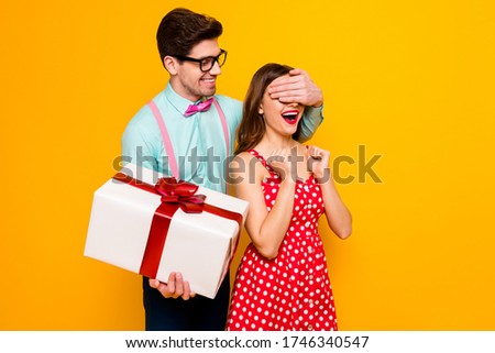 Photo of pretty lady handsome guy couple boyfriend giving girlfriend big gift box close eyes guess who game wear red dress shirt bowtie pants isolated yellow bright color background