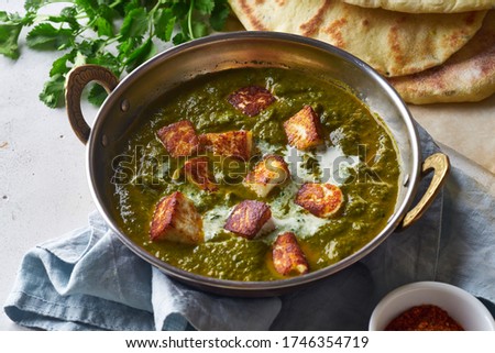 Vegetarian palak paneer starter. Indian cuisine, curry dish with soft cheese and spinach on concrete background