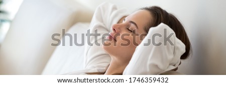 Serene woman leaned on comfy sofa put hands behind head resting in living room close up, enjoy carefree free day, breathing fresh air feels peaceful. Horizontal photo banner for website header design