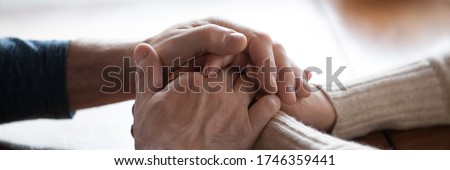 Middle-aged couple sit indoors holding hands close up photo. Spouses feeling connection and love, share problems express empathy showing compassion concept. Horizontal banner for website header design Royalty-Free Stock Photo #1746359441