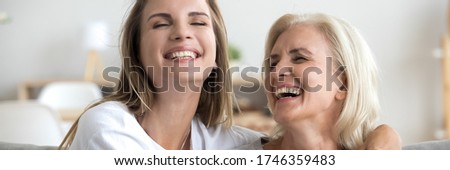Horizontal banner for website header design laughing grown up daughter hug mature 60s mother, beautiful positive women spend time together chatting enjoy communication joking having fun close up photo