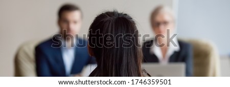Rear view woman applicant during job interview, out of focus two HR managers interviewing company position candidate. Hiring, human resources concept, horizontal photo banner for website header design