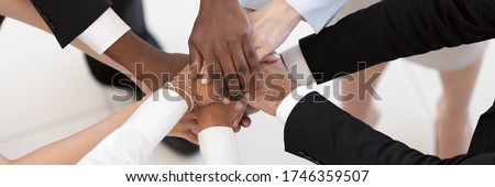 Close up top above view group of multi ethnic business people stacked palms together as concept of corporate unity, connection, team building loyalty. Horizontal photo banner for website header design