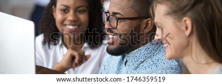 Multi ethnic colleagues mates work together using pc. African mentor explain application help to interns at group meeting. Coaching, teamwork concept. Horizontal photo banner for website header design Royalty-Free Stock Photo #1746359519