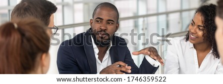 Multi ethnic employees involved in corporate training in boardroom, african team leader company boss business coach leading seminar activity concept. Horizontal photo banner for website header design Royalty-Free Stock Photo #1746359522